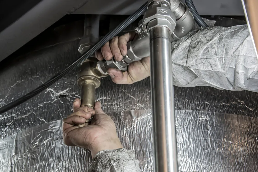 Technician fitting well system piping — illustrative stock photo of well service work, not an actual Pahrump job site