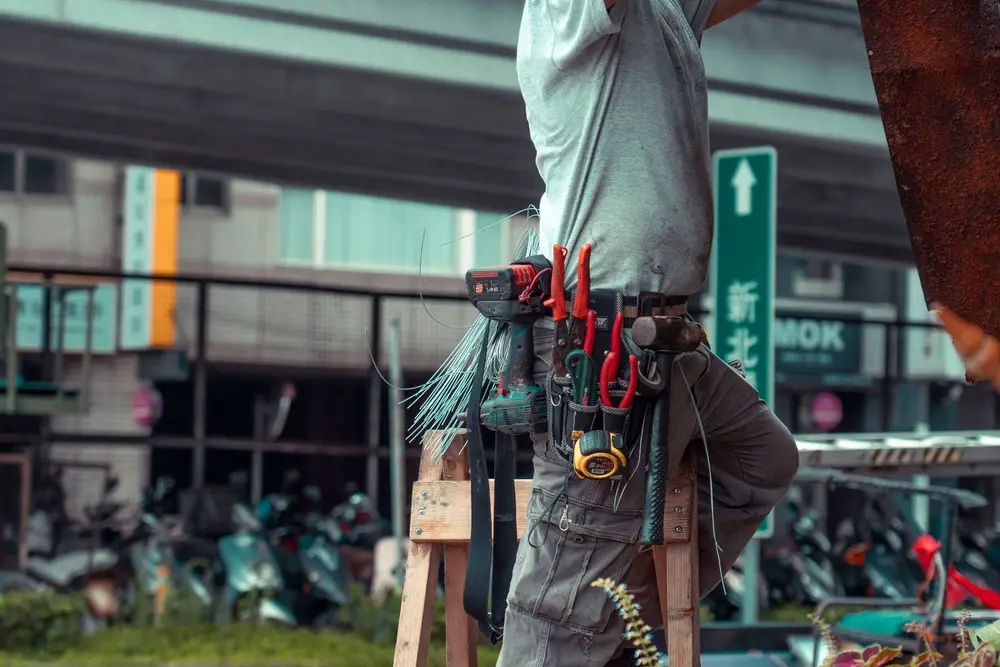 Technician on a ladder servicing outdoor well equipment — illustrative stock photo of well service work, not an actual Pahrump job site